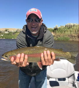 Jason Strand with rainbow fish on river